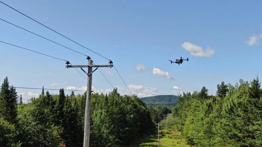 drone flying near power pole